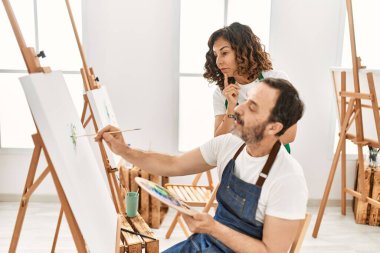 Sanat okulunda resim yapan orta yaşlı bir öğrenci ve öğretmen..