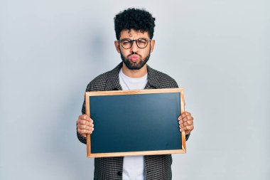 Sakallı, tahta göğüslü, komik yüzlü genç bir Arap. Ağzı havayla şişer, havayı yakalar.. 