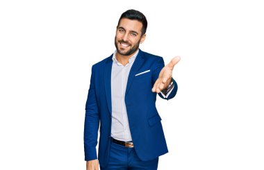 İş ceketi giyen, neşeli gülümseyen, yardım eli uzatan ve kabul gören genç İspanyol bir adam.. 