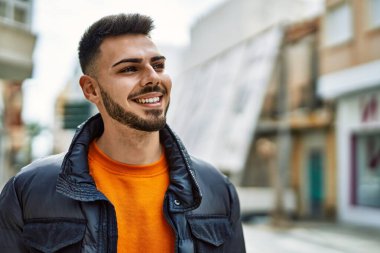 Yakışıklı, sakallı, neşeli ve kendine güvenen, kışlık palto giyen bir İspanyol.