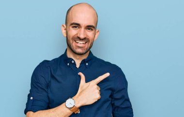 Gündelik kıyafetler giyen, neşeli, yüzünde gülümseme olan genç İspanyol adam mutlu ve doğal bir ifadeyle elini ve parmağını kaldırdı. 