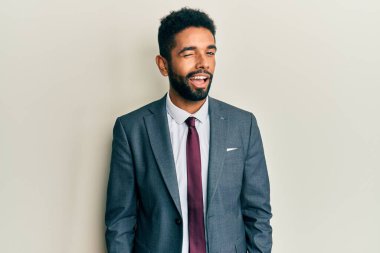 Yakışıklı, sakallı, takım elbiseli ve kravatlı seksi bir ifadeyle kameraya bakan neşeli ve mutlu yüzlü bir adam.. 