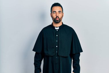 Sakallı, Katolik rahip cüppeli yakışıklı, dudağıyla balık suratı yapan, çılgın ve komik bir jest. Komik ifade. 