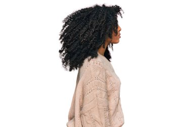 Afro-Amerikalı genç bir kız, günlük giysiler giymiş, rahat bir görünüm takınıyor, doğal bir yüz ifadesi ve kendine güvenen bir gülümsemeyle poz veriyor.. 