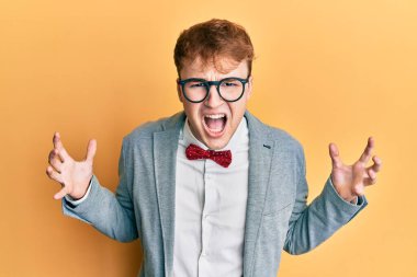 Genç, beyaz tenli, gözlüklü, hippi görünümlü, şık papyonlu deli deli deli bağıran, agresif ifadeli ve kolları havada bir inek. hüsran kavramı. 