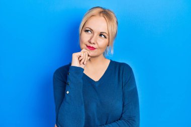 Sıradan mavi süveter giyen genç sarışın kadın şüphe üzerine yoğunlaşmıştı. Parmakları çenesinde ve yukarı bakıyordu. 