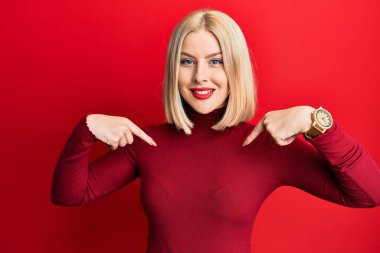 Gündelik kıyafetler giyen, kendine güvenen, gülümseyen, kendini gururlu ve mutlu gösteren genç sarışın kadın.. 