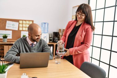 İki İspanyol iş adamı mutlu gülümsüyor. Ofise su döken ortak..