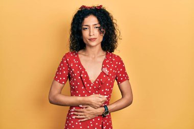 Yaz elbisesi giyen genç Latin kız midesi üzerinde çünkü hazımsızlık, acı verici bir hastalık kendini iyi hissetmiyor. Ağrı kavramı. 