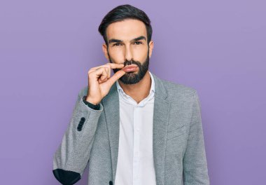 İş kıyafetleri giymiş genç İspanyol bir adam ağzı ve dudakları parmaklarıyla kapanmış bir fermuar gibi. gizli ve sessiz, tabu konuşması 