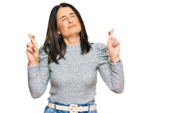 Orta yaşlı esmer kadın gündelik kıyafetler giyip umut ve gözlerin kapalı bir şekilde gülümseyerek bana işaret ediyor. Şans ve batıl inançlar. 