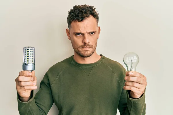 Ung Latinamerikansk Man Håller Glödlampa För Inspiration Och Idé Skeptisk — Stockfoto
