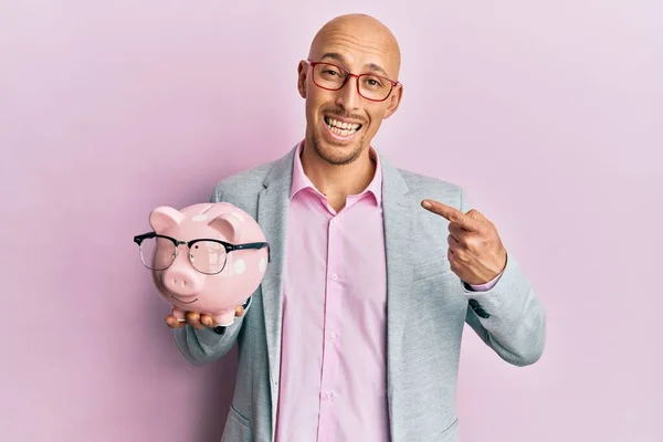 Glatzkopf Mit Bart Hält Sparschwein Mit Brille Und Lächelt Glücklich — Stockfoto