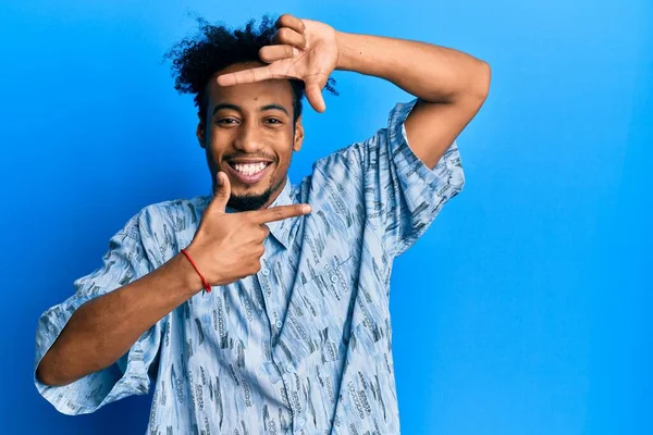 髭を生やした若いアフリカ系アメリカ人男性が 幸せな顔をした手や指でフレームを作って笑顔でカジュアルな服を着ている 創造性と写真の概念 — ストック写真