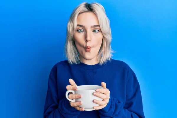 Ung Blond Flicka Dricker Kopp Kaffe Gör Fisk Ansikte Med — Stockfoto