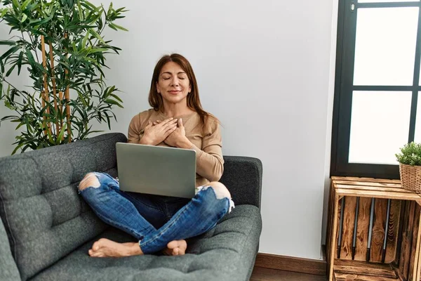 Wanita Senior Timur Tengah Menggunakan Laptop Duduk Sofa Rumah Tersenyum — Stok Foto