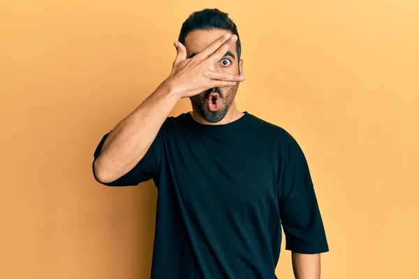 Jovem Hispânico Vestindo Roupas Casuais Espreitando Choque Cobrindo Rosto Olhos — Fotografia de Stock