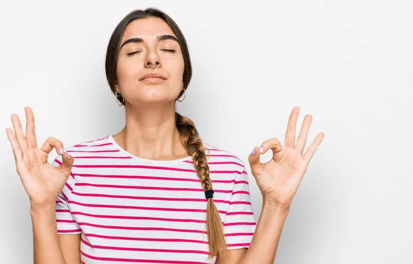 カジュアルな服を着た若いヒスパニック系の女性がリラックスし 指で瞑想ジェスチャーを行う目を閉じて笑顔 ヨガのコンセプト — ストック写真