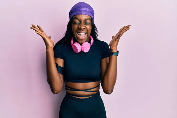 Mujer Afroamericana Joven Que Usa Ropa Gimnasio Usa Auriculares Celebrando —  Fotos de Stock