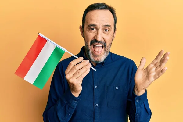 Homem Hispânico Meia Idade Segurando Bandeira Húngara Celebrando Realização Com — Fotografia de Stock