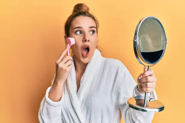 Mujer Rubia Joven Con Bata Sosteniendo Cepillo Removedor Maquillaje Asustado — Foto de Stock