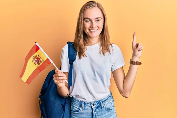 漂亮的金发女郎 拿着西班牙国旗 微笑着 带着一个想法或问题 满脸喜形于色地指指点点着别人 位居第一 — 图库照片