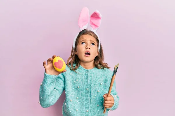 Gyönyörű Kislány Aranyos Húsvéti Nyuszifüleket Visel Kezében Színes Tojást Dühös — Stock Fotó