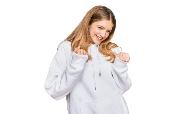 腕を上げて成功に興奮したカジュアルなスウェットシャツを着た美しい若い白人女の子が立ち上がり 勝利を笑顔で祝う目を閉じました 勝者のコンセプト — ストック写真