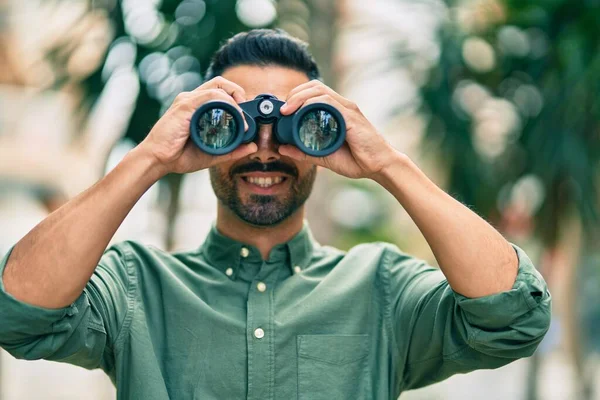 Young Hispanic Man Smiling Happy Looking New Opportunity Using Binoculars — Stock Photo, Image