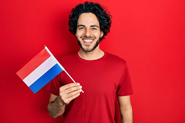 Snygg Latinamerikansk Man Håller Underlandet Flaggan Ser Positiv Och Glad — Stockfoto