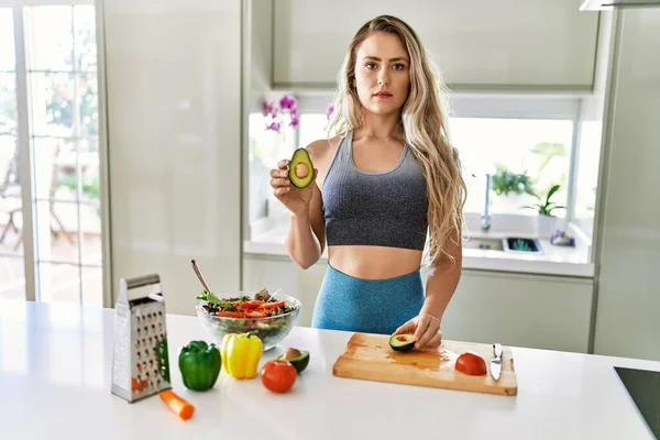 Beyaz Kadın Spor Kıyafetleri Giyiyor Mutfakta Sağlıklı Salata Hazırlıyor Düşünceli — Stok fotoğraf