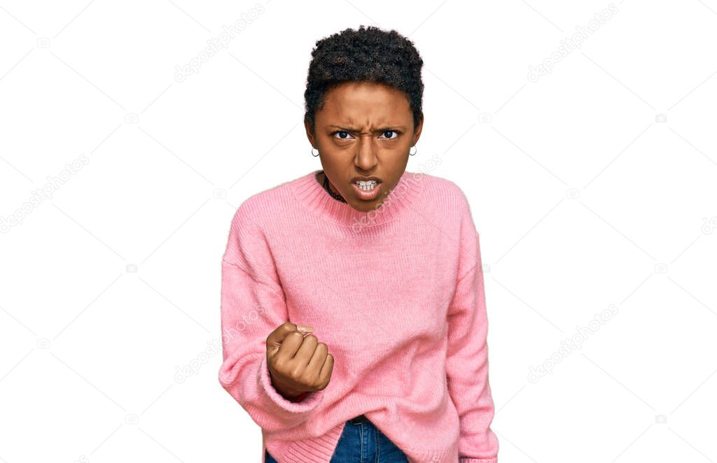 Young african american woman wearing casual clothes angry and mad raising fist frustrated and furious while shouting with anger. rage and aggressive concept. 