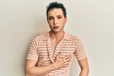 Makyaj yapan yakışıklı, sıradan bir gömlek giyen, gülümseyen, mutlu, el pençe divan duran, el pençe divan duran bir adam. 