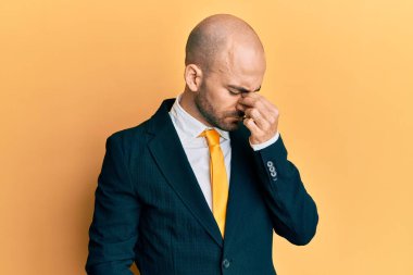 Genç İspanyol takım elbiseli ve kravatlı adam yorgun burnu ve gözleri ovuşturup yorgun ve baş ağrısı çekiyor. Stres ve hüsran kavramı. 