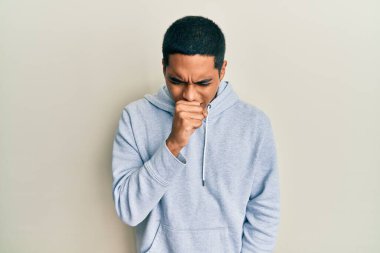 Genç, yakışıklı, sıradan bir kazak giyen, kendini kötü hisseden ve soğuk algınlığı veya bronşitin belirtisi olarak öksüren bir İspanyol. sağlık hizmeti kavramı. 