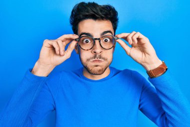 Gözlüklü, komik yüzlü, yanak şişiren genç bir İspanyol. Ağzı havayla şişer, havayı yakalar.. 