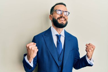 Sakallı, takım elbiseli ve kravatlı genç adam. Kolları havada ve gözleri kapalı zaferi kutluyor. Kazanan konsept. 