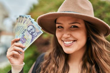 Genç İspanyol turist gülümseyerek Romanya Lei 'nin paralarını şehirde tutuyor..