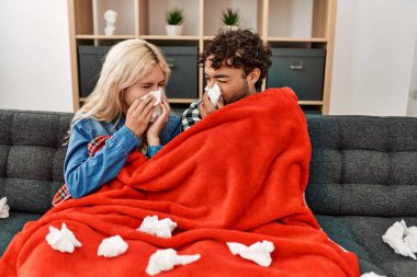 Genç hasta çift evdeki kanepede peçete kullanıyor..