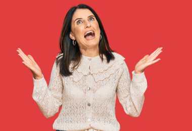 Orta yaşlı esmer kadın, gündelik giysiler giyip başarının çılgınlığını kutluyor. Kolları havada, gözleri kapalı, heyecanla bağırıyor. Kazanan konsept 