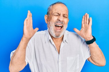 Yakışıklı, sakallı, gündelik beyaz tişörtlü, çılgın ve başarıyı kolları havada ve gözleri kapalı, heyecanlı bir şekilde kutlayan yakışıklı bir adam. Kazanan konsept 