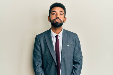 Sakallı, takım elbiseli ve komik yüzlü, yanakları şişen yakışıklı bir İspanyol. Havayla şişmiş ağız, çılgın bir ifade.. 