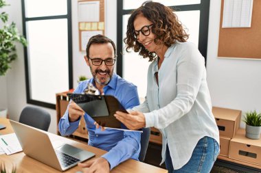 Ofiste çalışırken gülümseyen iki orta yaşlı iş adamı..