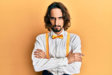Genç İspanyol bir adam hippi gibi şık giyiniyor. Şüpheli ve gergin görünüyor. Yüzünde çapraz kollu tasvip etmeyen bir ifade var. negatif kişi. 