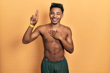 Mayo ve yüzücü gözlüğü takan genç Afro-Amerikan bir adam. Gülümsüyor, yemin ediyor. 