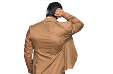 Genç İspanyol adam iş kıyafetlerini ters giyip elleri kafasında şüpheyi düşünüyor. 