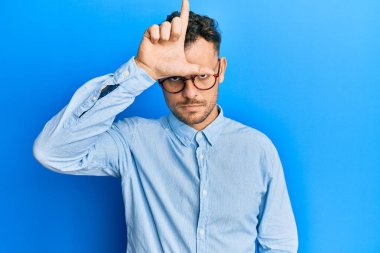 Gündelik kıyafetler ve gözlük takan genç İspanyol adam. Alnında parmakları olan insanlarla dalga geçiyor. Ezik hareketler yapıyor, alay ediyor, hakaret ediyor.. 