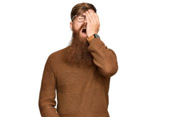 Genç İrlandalı kızıl adam, günlük kıyafetler ve gözlük takıyor. Yorgun esniyor. Yarı yüz, yarı göz, yarı ağız ve el ile esniyor. Yüzüm acıyor.. 