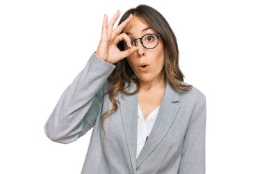 İş kıyafetleri giyen genç esmer kadın şaşırmış yüz ifadesiyle şok olmuş, parmaklarından bakan gözler. İnançsız ifade. 