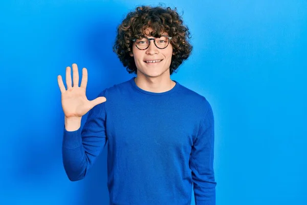 Przystojny Młody Człowiek Luźnych Ubraniach Okularach Pokazujący Wskazujący Palcami Numer — Zdjęcie stockowe